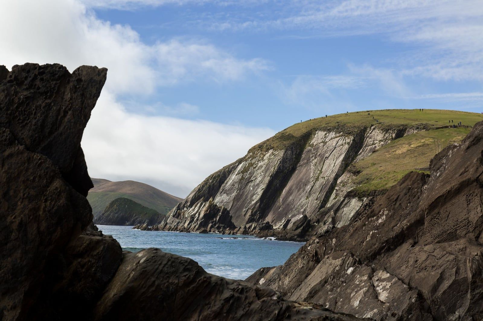 Steep rocky cliffs of Dunmore Head rise over the Atlantic Ocean along the Dingle Peninsula, a scenic counterpart to the Ring of Kerry.